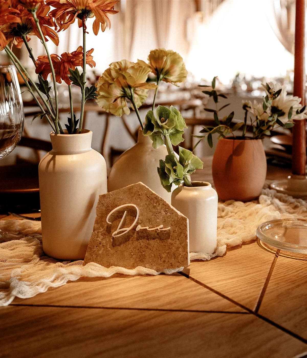 Detalle de mesa con menú, velas y piezas decorativas